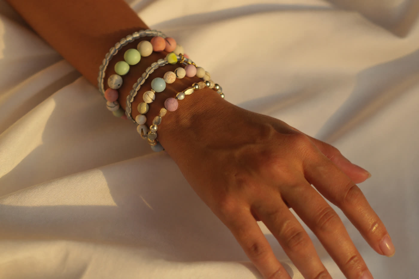 A wrist stacked with handmade M by Maddison bracelets